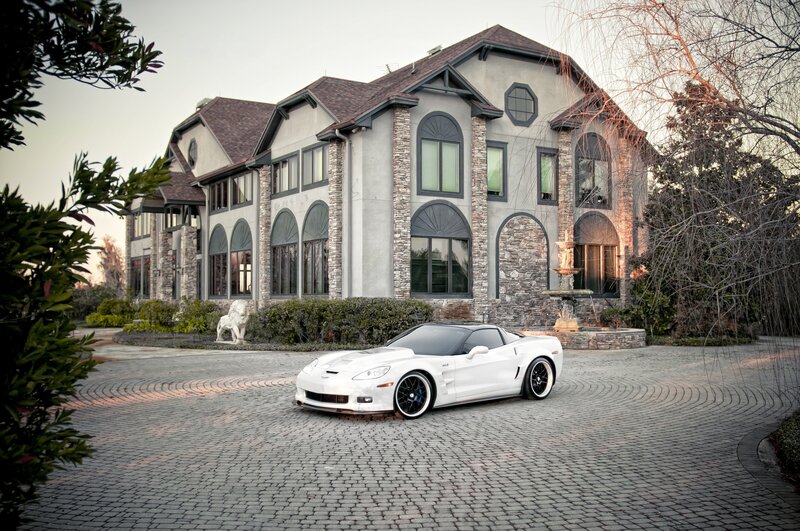White sports car in front of mansion