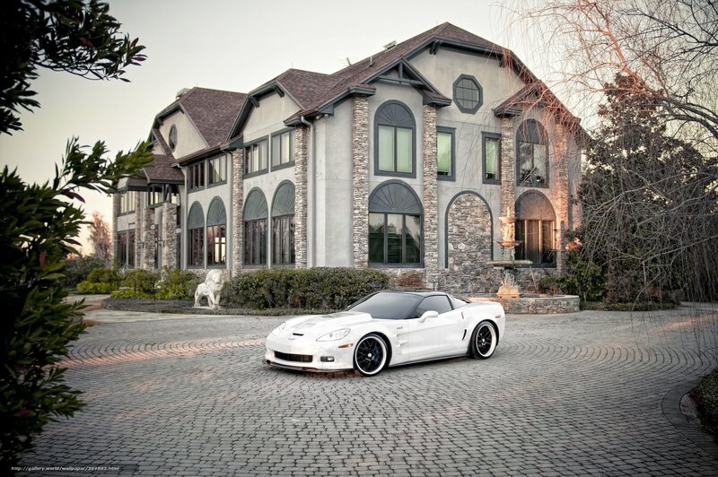 White sports car in front of mansion