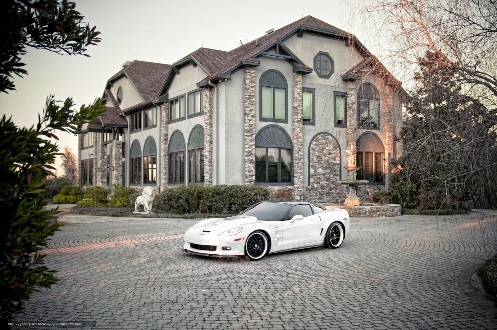 White sports car in front of mansion