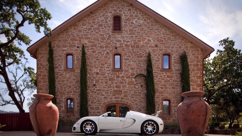 White sports car in front of stone house
