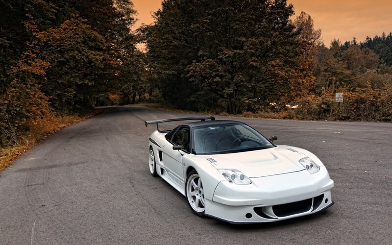 White sports car on a forest road