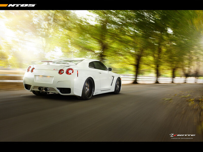 White sports car on a tree-lined road