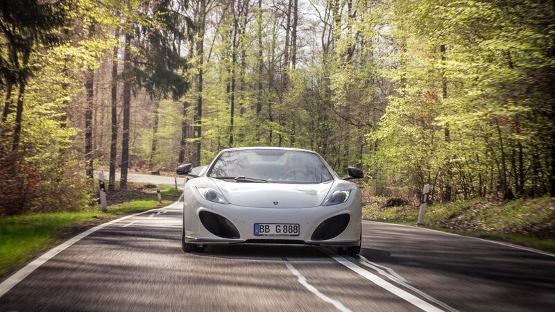 White sports car on forest road