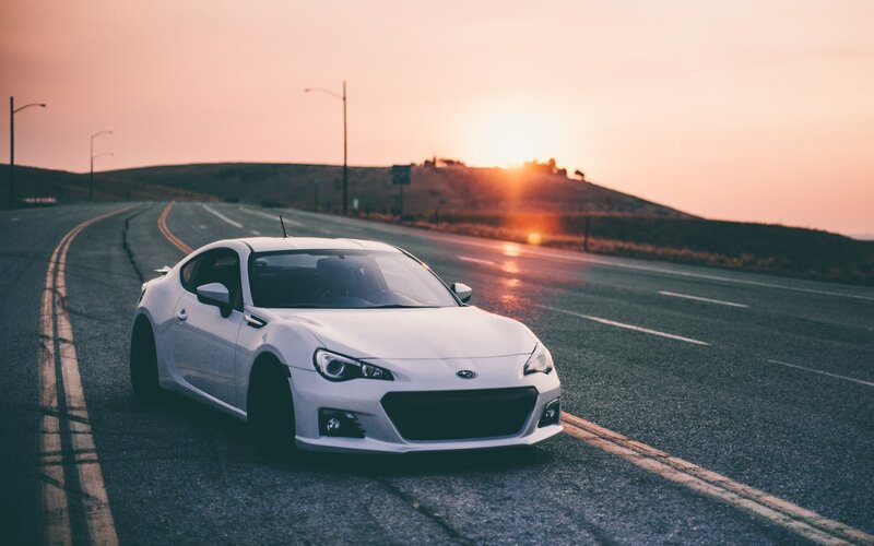 White sports car on road at sunset