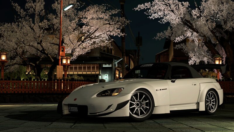 White sports car under cherry blossoms