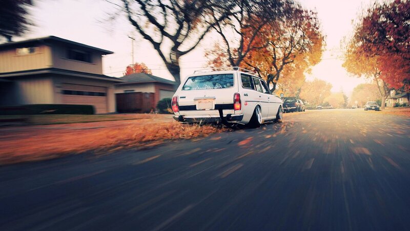 White station wagon driving on autumn street