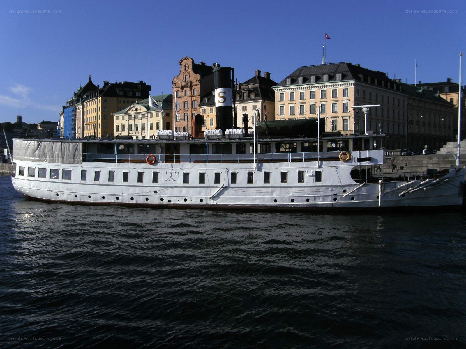 White steamship in city harbor
