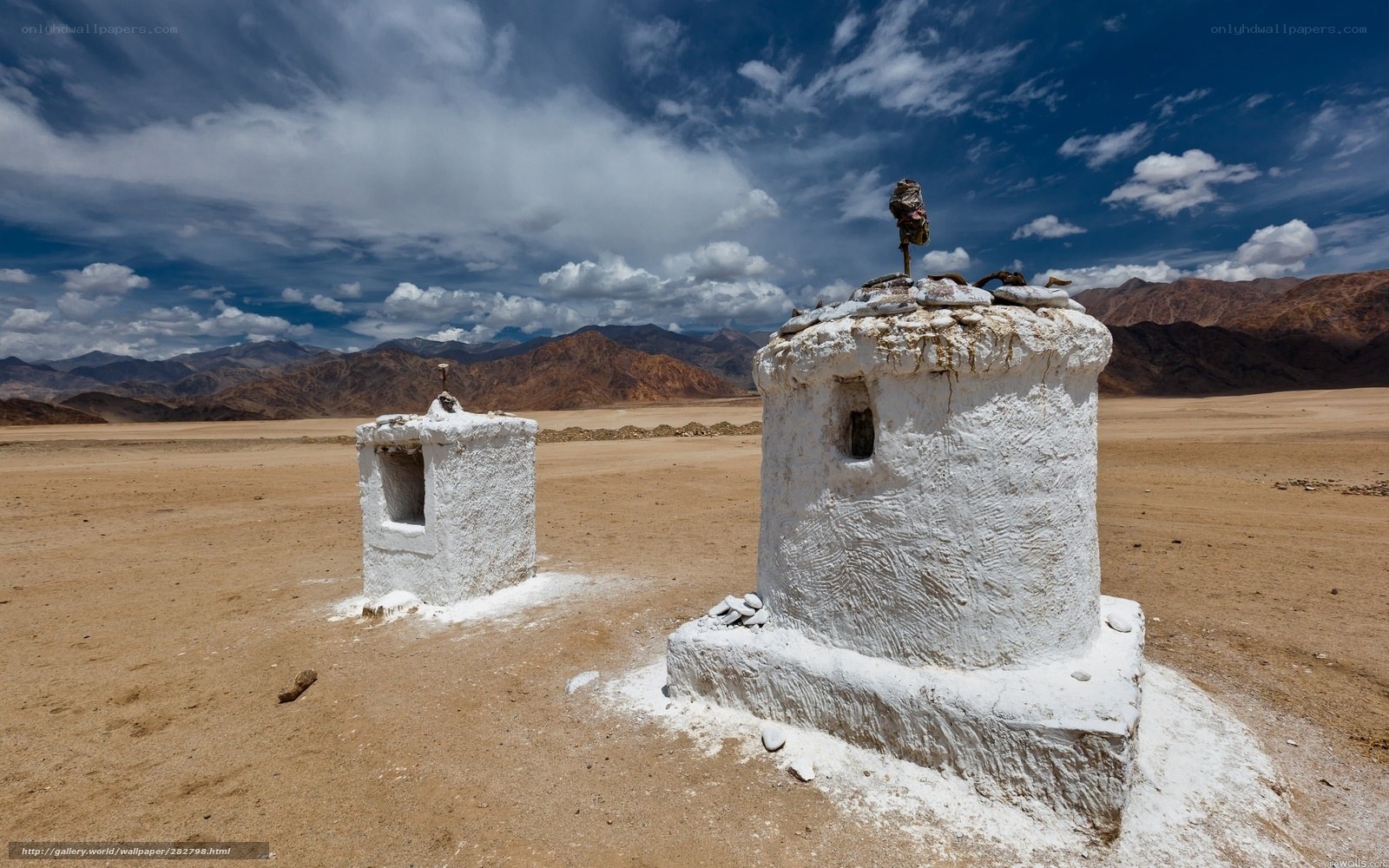 White stupas in desert landscape