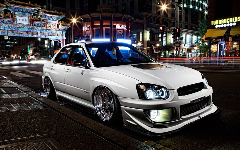 White Subaru in Chinatown at night