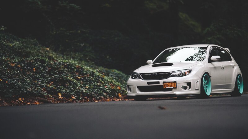 white subaru on a forest road