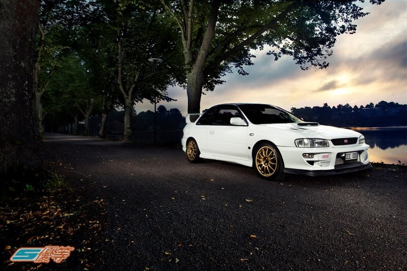 White Subaru on a lakeside path