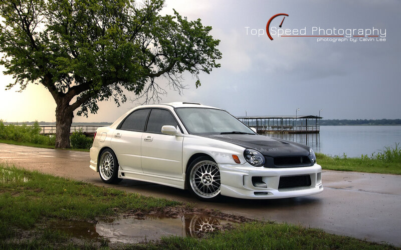 white subaru on lakeside road