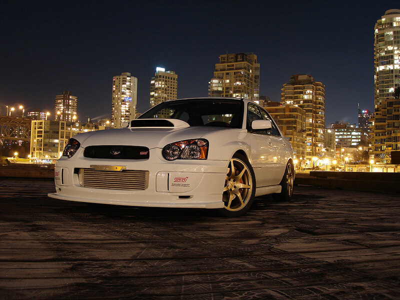 white subaru on rooftop at night