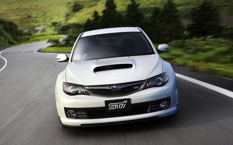 white subaru sti on winding road