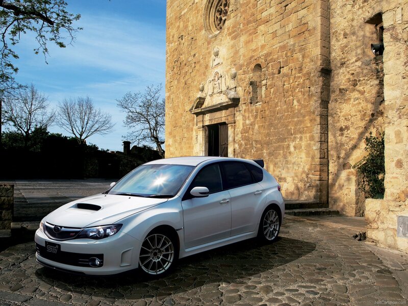 White Subaru STI parked by church
