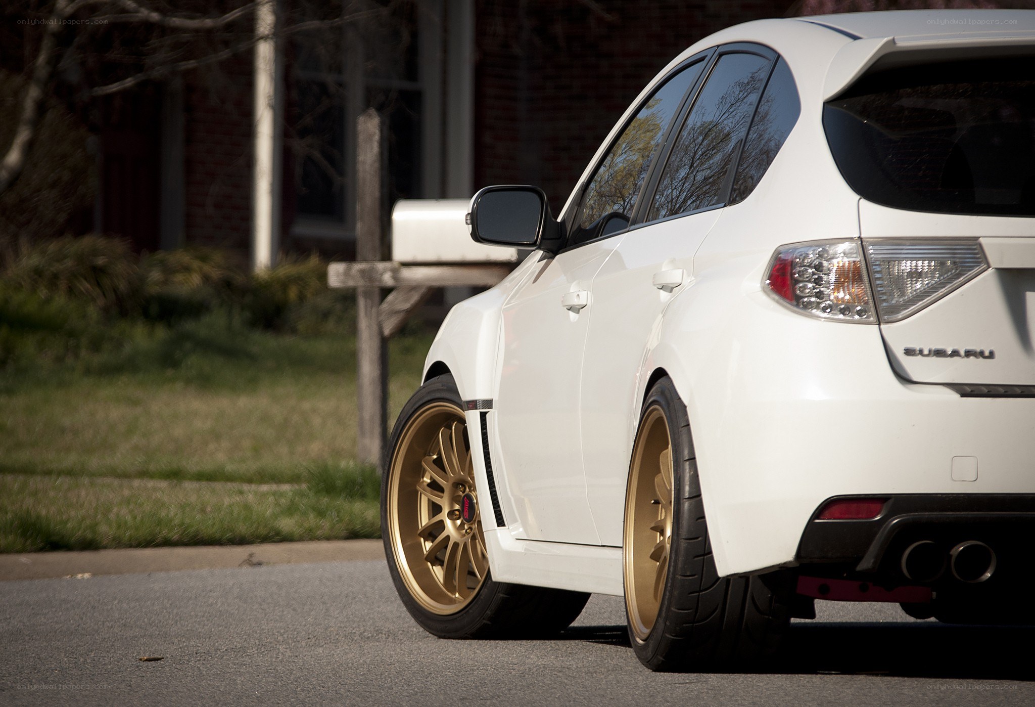 white subaru with gold wheels