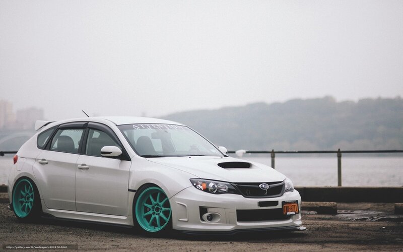 white subaru with teal wheels