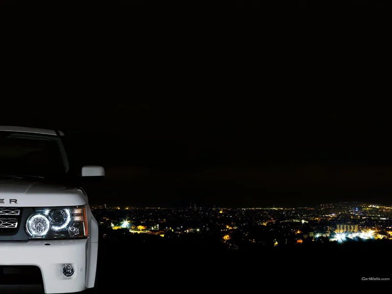 White SUV at night overlooking city