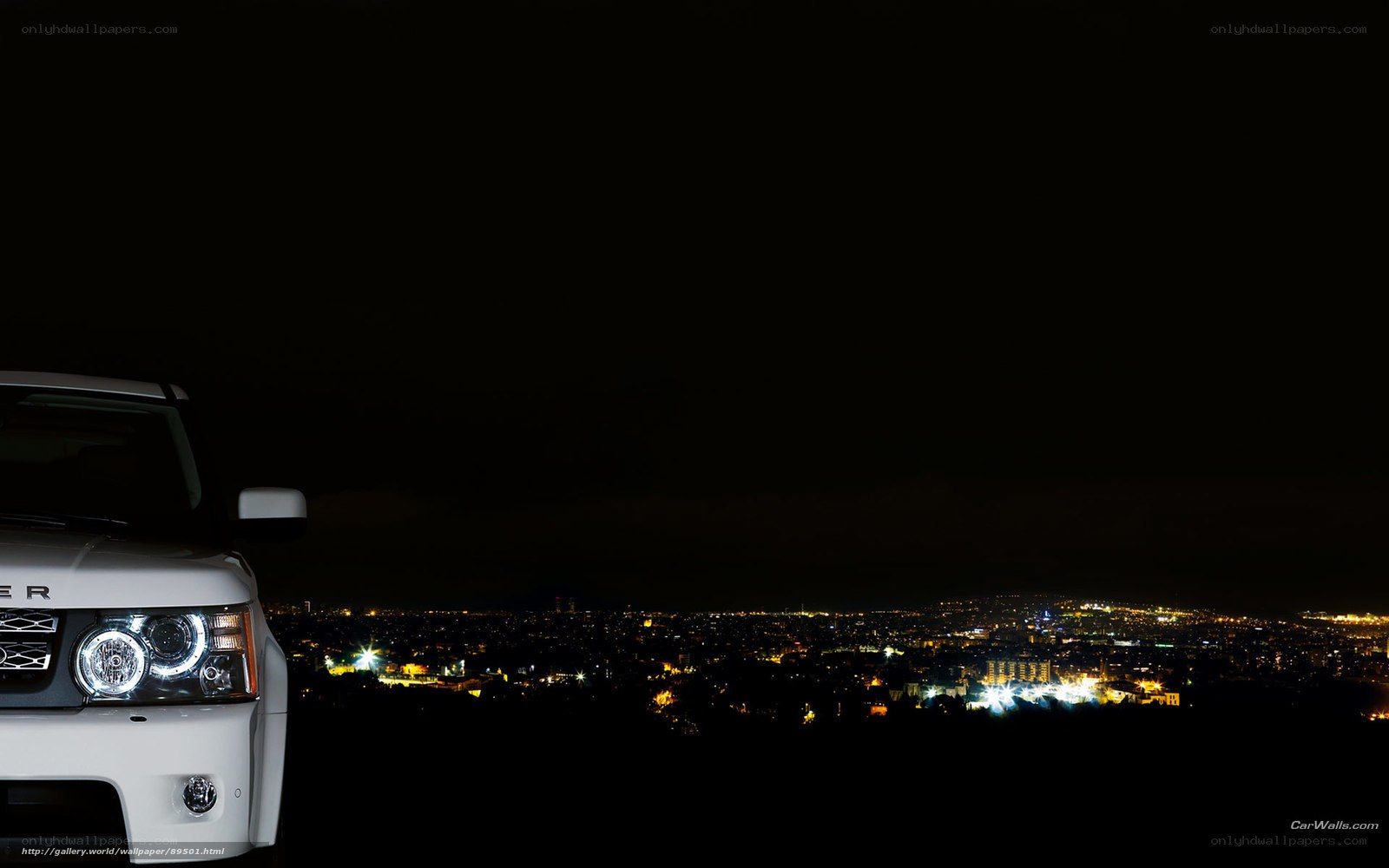 White SUV at night overlooking city