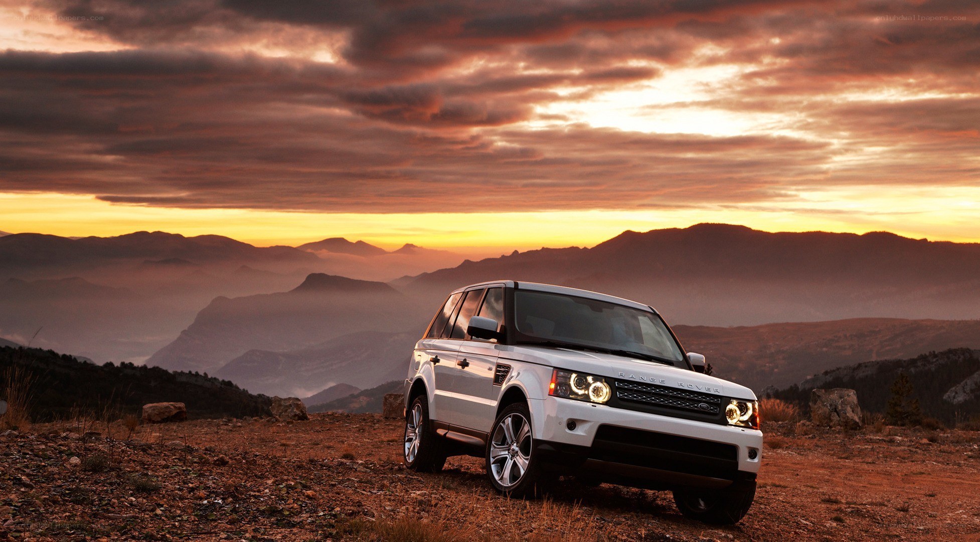 White SUV at sunset in mountains