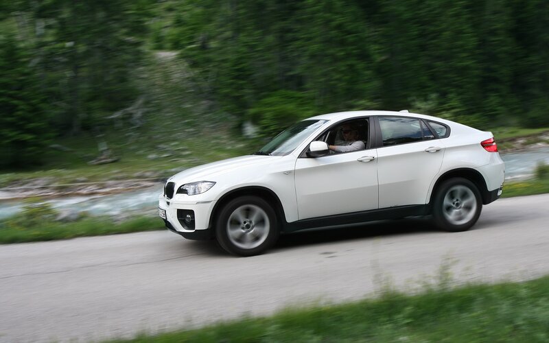 White SUV driving on a road