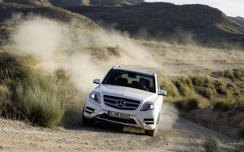 White SUV driving on dirt road