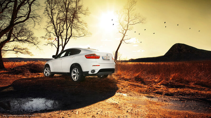 White SUV in sunset landscape