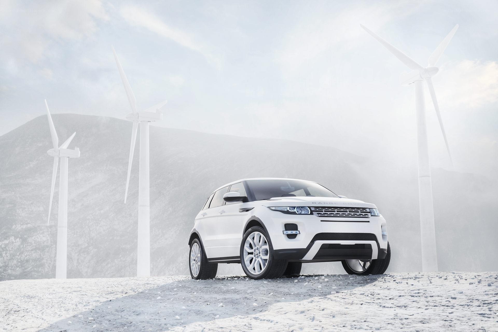 White SUV near wind turbines