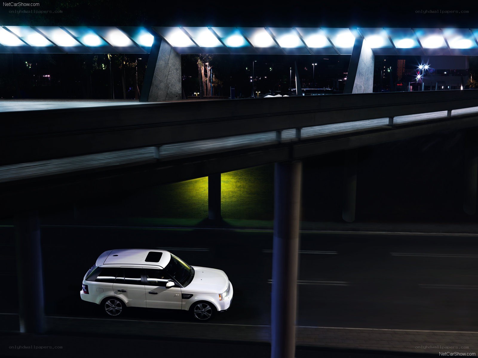 White SUV under a bridge at night