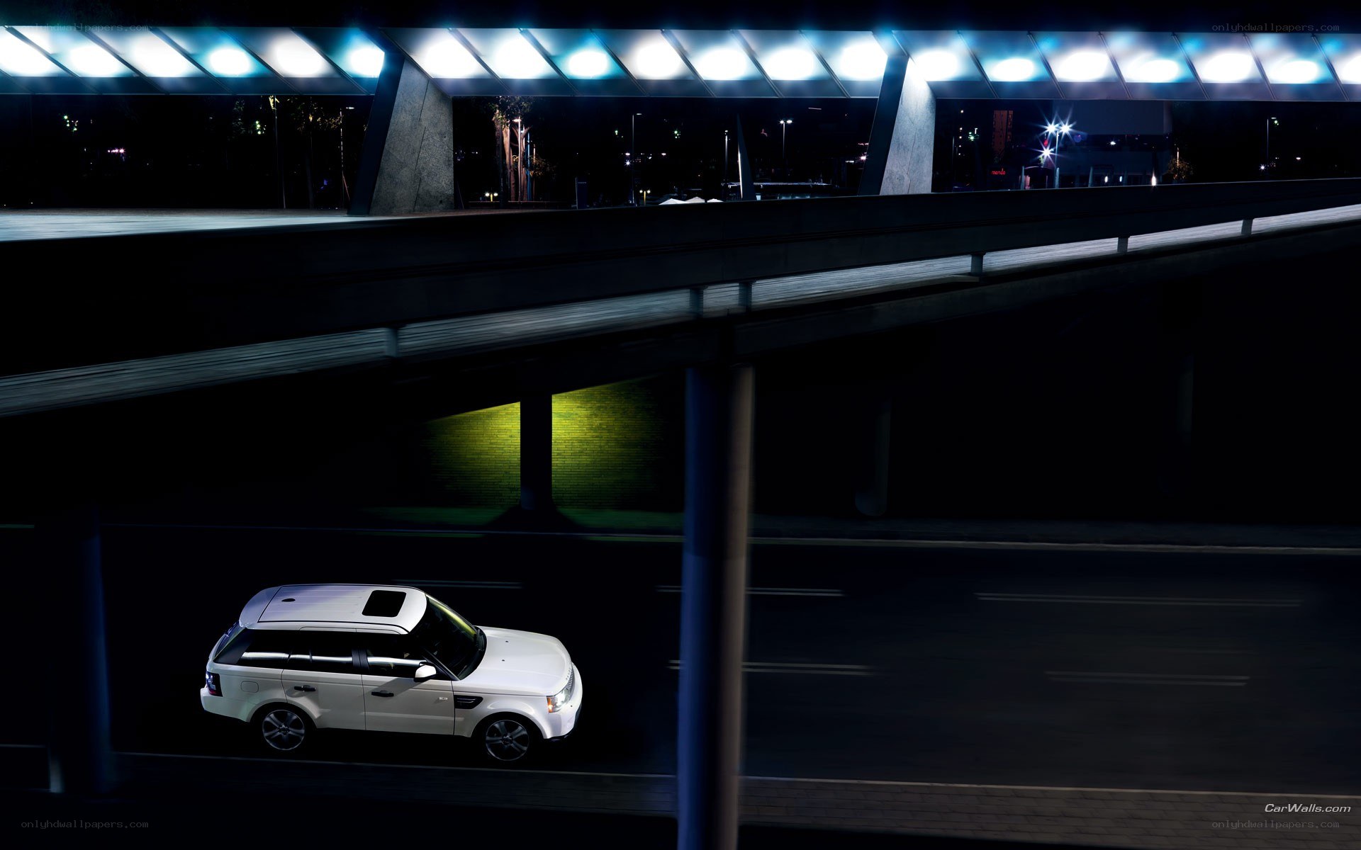White SUV under a bridge at night