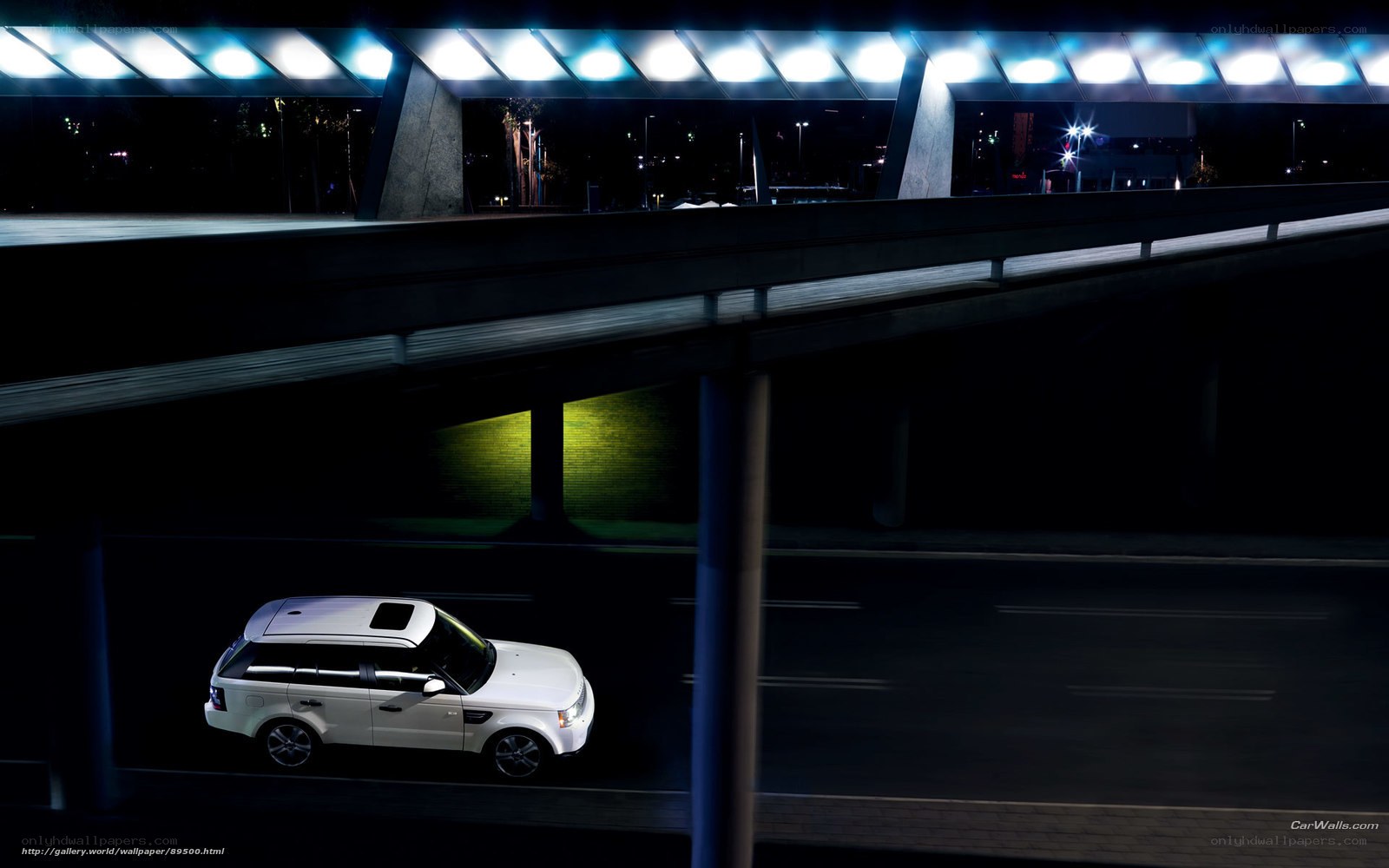 White SUV under highway at night