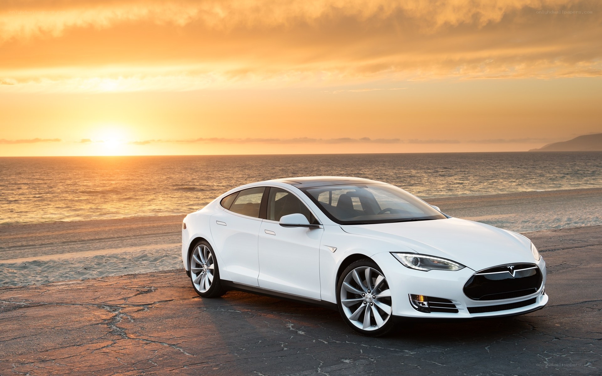 White Tesla on beach at sunset
