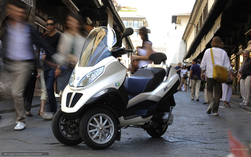 White three-wheeled scooter in city street