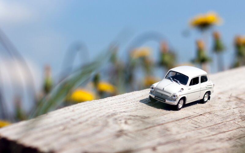 White toy car on wooden surface