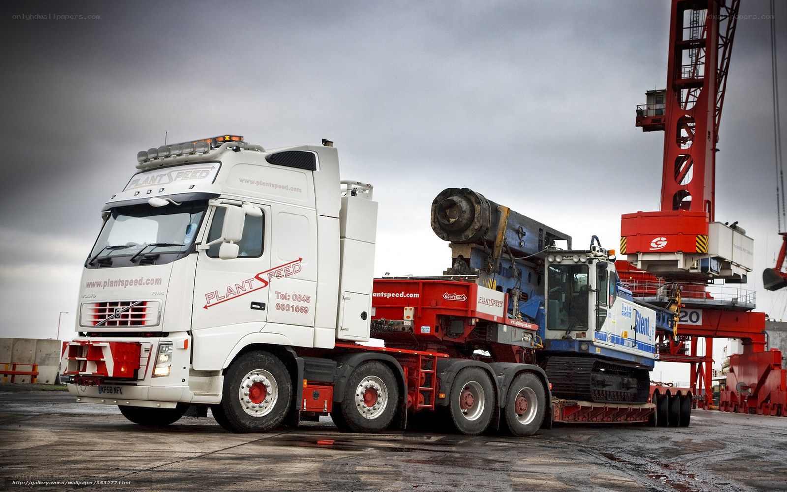 White truck carrying heavy machinery
