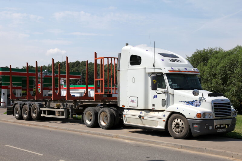 White truck with flatbed trailer