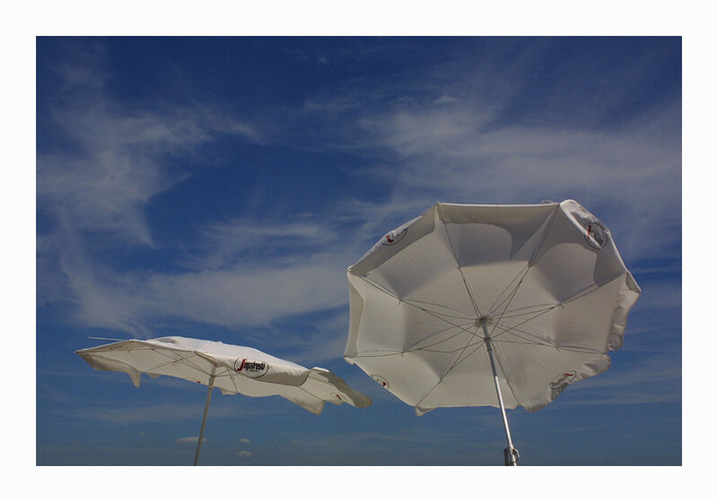 White umbrellas against blue sky