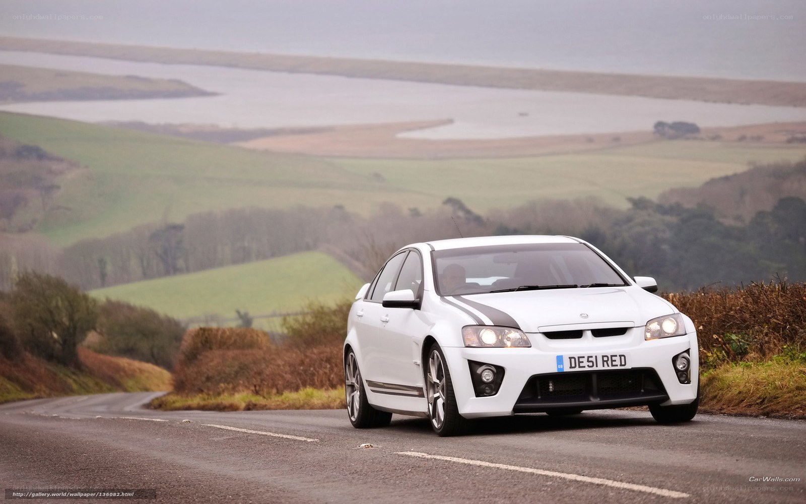 White V8 sedan on a country road