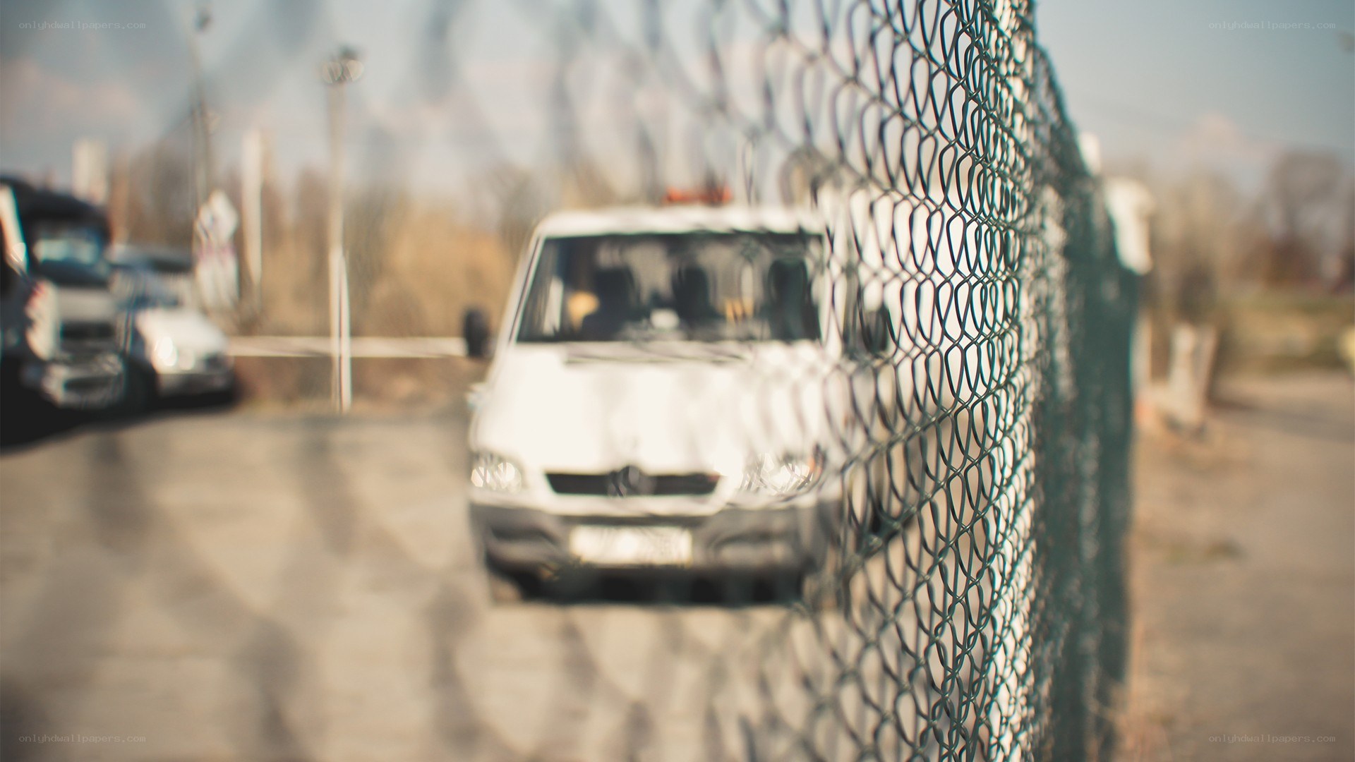 white van behind chain-link fence