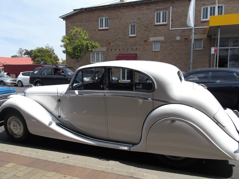 White Vintage Car — Calm, Afternoon, Photograph, Brick Building