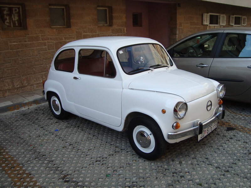 White vintage car parked on cobblestones