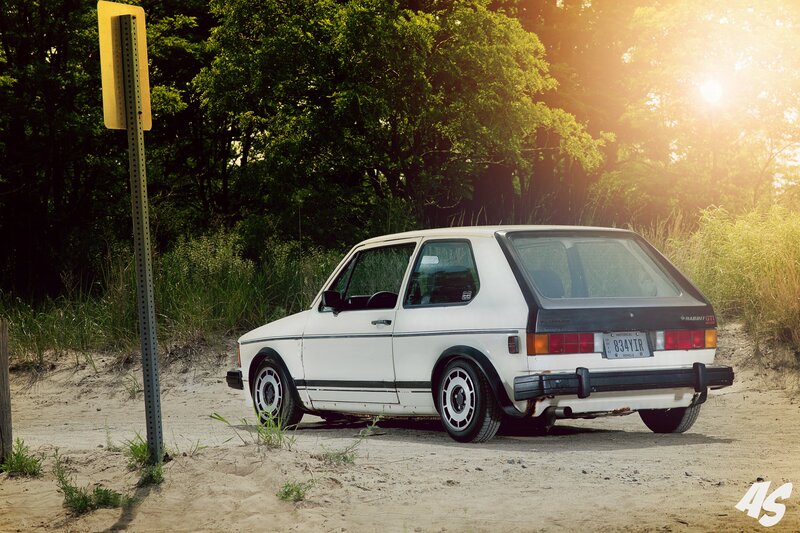 White Volkswagen Rabbit GTI on a sandy path