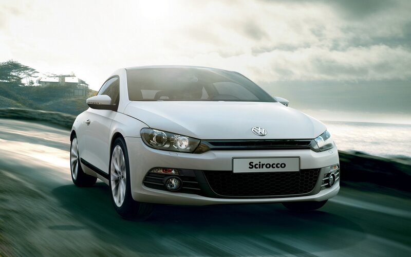 White Volkswagen Scirocco on coastal road
