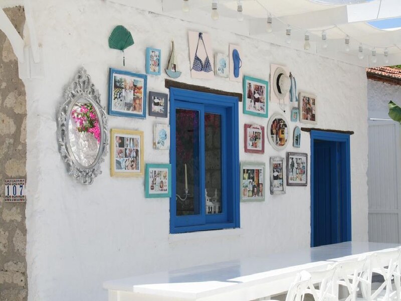 White wall with blue window and photos