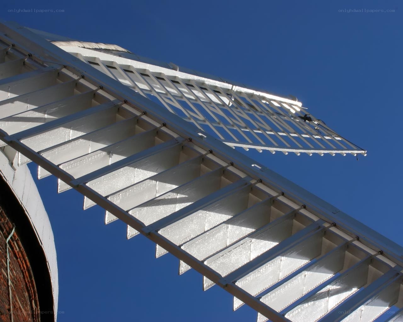 white windmill blades against blue sky