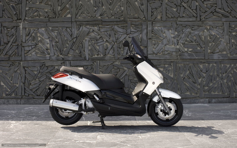 White Yamaha scooter on stone wall