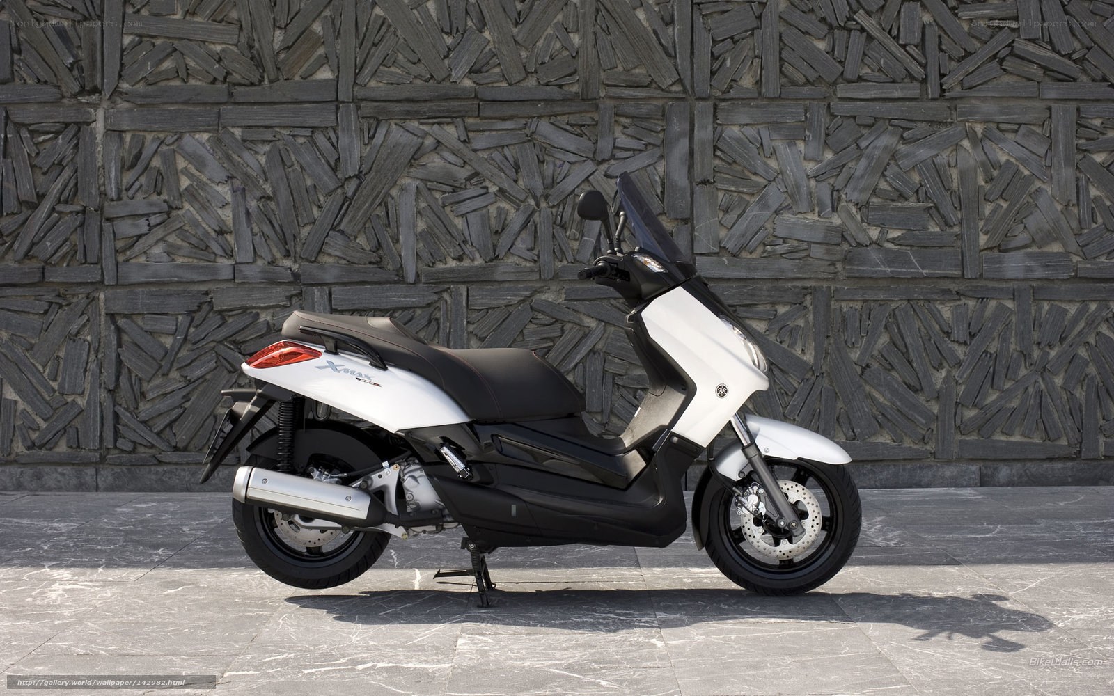 White Yamaha scooter on stone wall