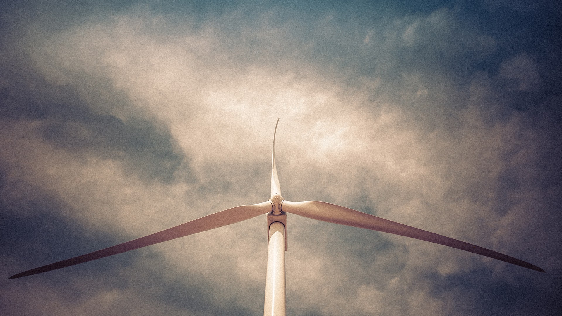 Wind turbine against cloudy sky