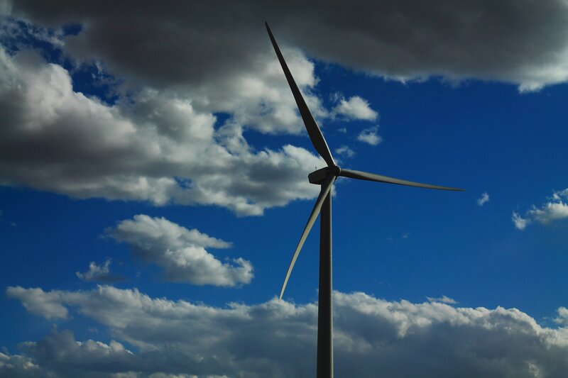 Wind turbine against cloudy sky