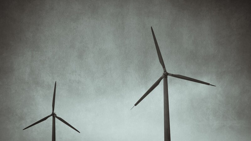 wind turbines against gray sky